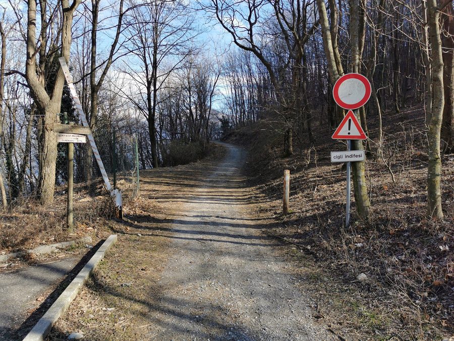 Beginn des Weges von Breglia zur Kapelle San Domenico mit geöffnetem Absperrgitter und Verbotsschild für Fahrzeuge